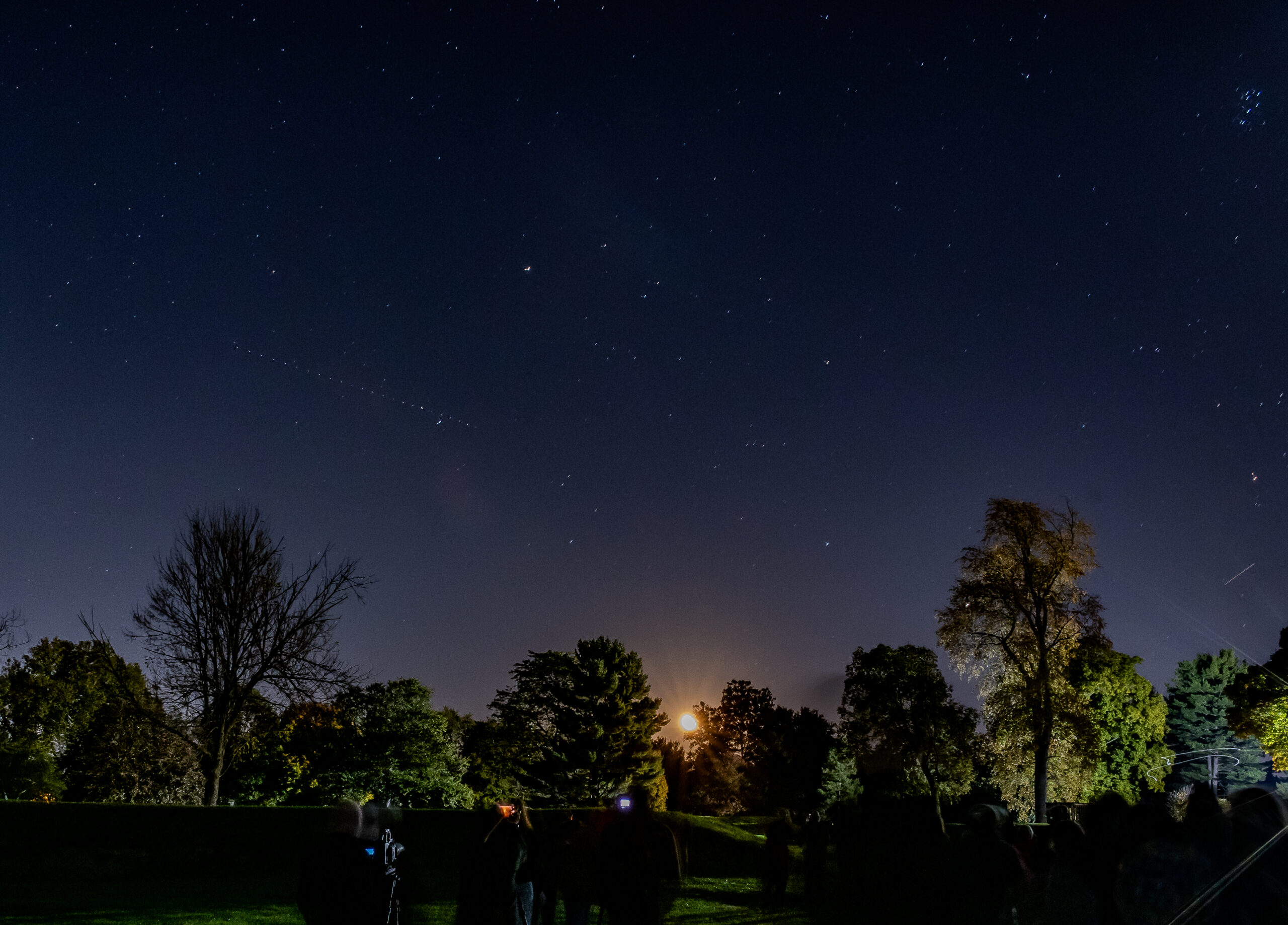 Image of the moon peeking over the mounds at the Octagon Earthworks.