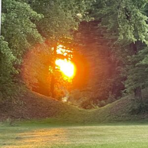 Sun peaking through the twin mounds at Fort Ancient.